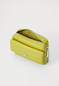 Borsa a pochette in pelle verde lime con chiusura a zip argentata, tasca frontale e logo argentato. Texture liscia con design strutturato.