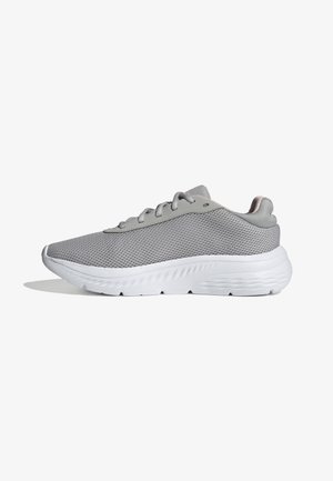 Zapatilla deportiva gris con parte superior de malla, acentos suaves y suela de goma blanca con detalles texturizados. Contiene cordones planos y punta redondeada.