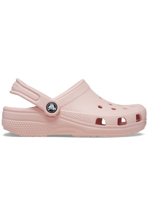 Zueco de goma de color rosa claro con agujeros de ventilación, correa trasera, lado texturizado y logotipo circular. Diseño suave con forma ergonómica para mayor comodidad.