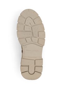 Semelle en caoutchouc tan avec un motif de relief texturé, présentant de profonds sillons et crêtes pour une meilleure adhérence. Marquage gravé sur la semelle.