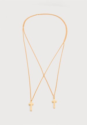 Goudkleurige halsketting met twee kleine kruisvormige hangers, verbonden door fijne kettingen, op een effen witte achtergrond.