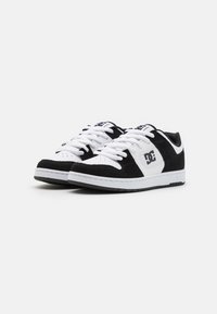 Black and white skate shoes with suede and leather materials, flat white laces, and logo accent on the side. Rubber sole with textured grip.