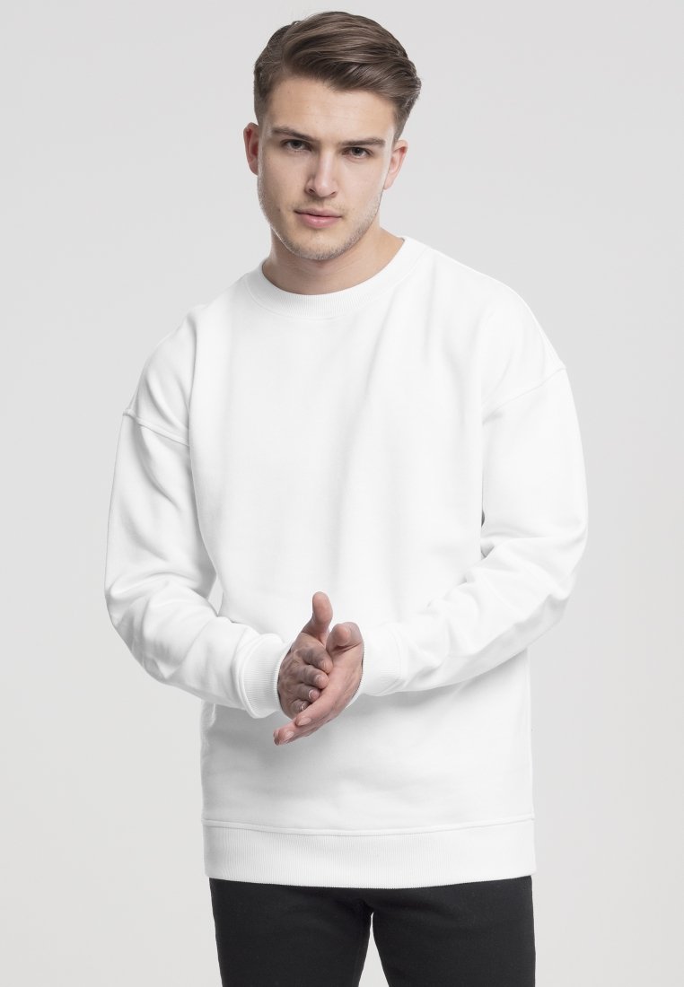 Witte sweatshirt met een ronde halslijn, verlaagde schouders en geribbelde manchetten. De stof lijkt zacht en glad, zonder zichtbare patronen.