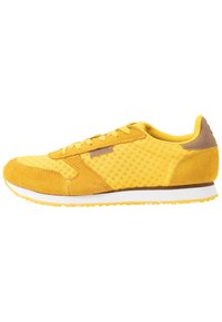 Gelbe Sneaker mit Obermaterial aus Mesh und Wildlederakzenten. Verfügt über eine weiße Zwischensohle und eine strukturierte Sohle für besseren Halt. Schnürdesign.