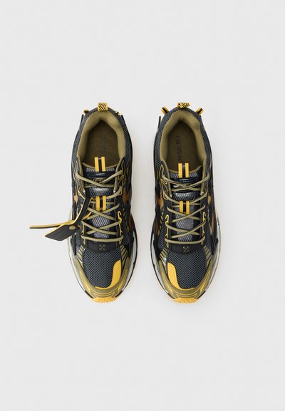Μαύρα και κίτρινα αθλητικά παπούτσια με ανώτερο μέρος από δίχτυ και συνθετικό υλικό, σύστημα κορδονιών, υφασμάτινες λεπτομέρειες και ρυθμιζόμενο τακούνι. Λαστιχένια σόλα.