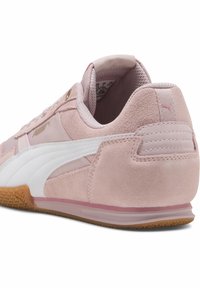 Zapatillas de deporte rosas claras con parte superior de ante y sintético, detalles en blanco, puntera redonda, suela de goma texturizada y tobillo acolchado para mayor soporte.