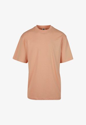 Lühikeste varrukatega, ümarate kaelustega t-särk heledas virsikuvärvis, valmistatud pehmest puuvillakangast, millel on sile tekstuur ja mugav lõige.