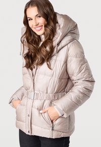 Helle beigefarbene Daunenjacke mit tailliertem Schnitt, großer Kapuze und Reißverschlusstaschen. Verfügt über eine gesteppten Textur und silberne Hardware-Akzente.