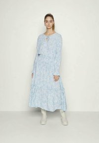 Vestido azul de flores com mangas longas, saia em camadas, detalhe de laço no pescoço e um ajuste descontraído. O tecido tem uma textura suave e padrões subtis.