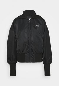 Veste bomber noire en matériau brillant, avec un col haut, des poignets côtelés et une fermeture éclair à l'avant, arborant un logo Adidas près de la poitrine.