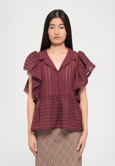 Bordeaux peplum blouse met ruffle mouwen, verticale strepen en een knoopsluiting aan de voorkant. Draagt met een patroonrok. Glad textuur.
