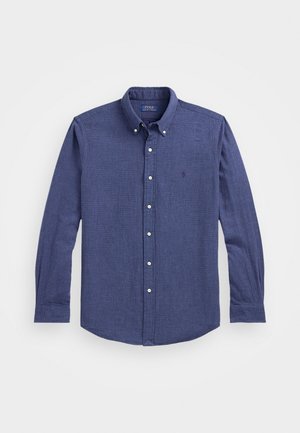 Chemise bleue à manches longues avec col, boutons blancs et logo Polo Ralph Lauren discret sur la poitrine.