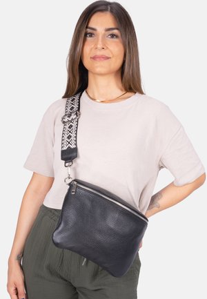 Schwarze Leder-Crossbody-Tasche mit strukturierter Oberfläche, ausgestattet mit einem gemusterten verstellbaren Tragegurt und einem silbernen Reißverschluss.