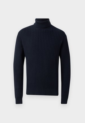 Pull en col roulé marine avec un motif texturé en maille gaufrée. Il possède des manches longues et un col, des poignets et un ourlet côtelés. Matériau doux.