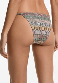 Többszínű bikini alsó, textúrázott, szőtt mintázattal zöld, rózsaszín és narancssárga árnyalatokban. Vékony oldalpántok egészítik ki a dizájnt.