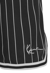 Svarta träningsshorts med vita ränder, en kontrasterande midja och en signaturlogo nära fållen. Texturerad, andningsbar tyg.