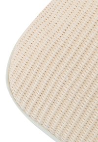 Tappeto intrecciato di colore beige chiaro, con bordi arrotondati e superficie textured. Il motivo dell'intreccio è uniforme e compatto, evidenziando le fibre naturali.