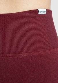 Bordeaux leggings met een geribde tailleband. Gemaakt van zacht, rekbaar materiaal met een klein merketiketje dat op de tailleband is gestikt.
