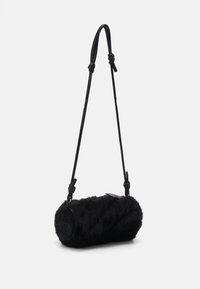 Borsa a tracolla in pelliccia nera con forma cilindrica, dotata di una tracolla in pelle e dettagli annodati. Texture morbida con finitura senza cuciture.