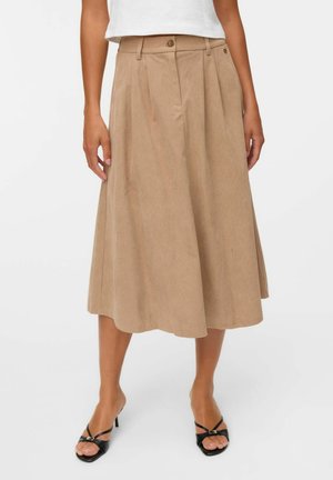 Beige midi kjol gjord av lättviktig tyg, med veck, en knappstängning i midjan och en flödande fåll. Bärs med svarta sandaler.