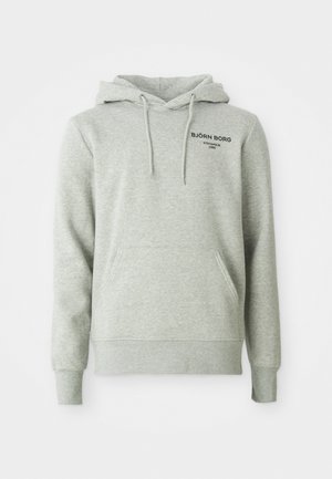 Hoodie cinza claro com bolso frontal, cordões e "BJÖRN BORG STOCKHOLM 1956" impresso a preto no lado esquerdo do peito.