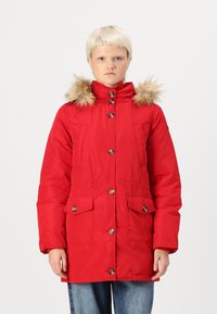 Piros parkajacket bunda szőrmebéléses kapucnival, gombos elülső résszel, két nagy zsebbel és rugalmas derékrésszel a testre simuló megjelenés érdekében.