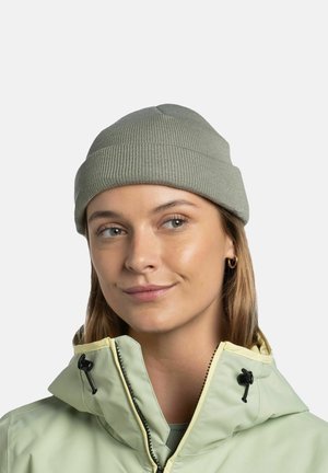 Light green ribbed knit beanie; soft texture, form-fitting design. Worn with a light green jacket featuring a yellow trimmed collar.