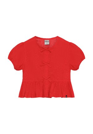 Czerwona bluzka z krótkim rękawem z bufkami, z wzorem gwiazdek i ozdobnymi kokardami z przodu, wykończona rozszerzanym dołem.