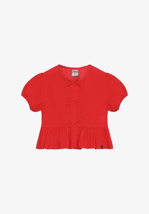 Blouse rouge à manches courtes bouffantes, ornée d'un motif d'étoiles et de nœuds décoratifs à l'avant, finition avec un ourlet évasé.