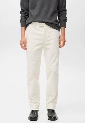 Pantalones color crema con diseño de pierna recta, hechos de una mezcla de algodón. Cuentan con un cierre frontal de cremallera y botón, estilo minimalista.
