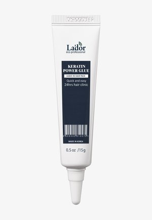 Lador Keratin Power Glue dans un tube blanc, avec une étiquette bleue comportant du texte. Comprend un embout pour l'application. Capacité de 15g.