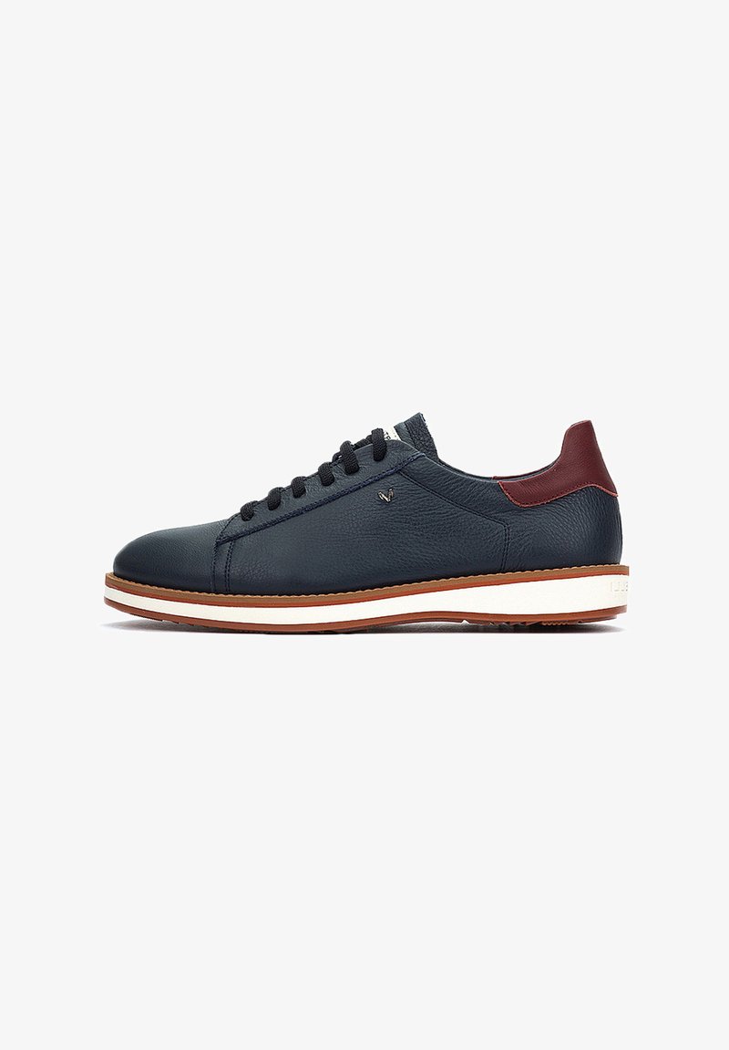 Sneakers in pelle con tomaia di colore blu navy, accento bordeaux sul tallone e suola intermedia bianca. Presentano lacci scuri e superficie texturizzata.