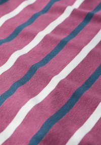 Tkanina bawełniana o teksturowej powierzchni z naprzemiennie występującymi falistymi paskami w kolorze różowym, białym i ciemnoniebieskim, tworzącymi rytmiczny wzór.