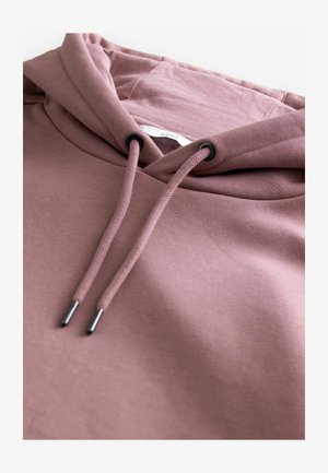 Felpa rosa con cappuccio regolabile, dotata di terminazioni in metallo. Il tessuto appare morbido e liscio con una leggera texture.