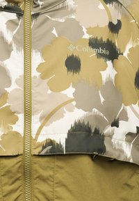 Μπουφάν Columbia με λουλουδάτο σχέδιο σε αποχρώσεις καφέ, μπεζ, μαύρο και ταμπά φερμουάρ στη μέση.