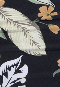 Tissu floral avec un fond noir présentant de grandes feuilles vert clair et blanches, des fleurs orange et des détails subtils dans une texture lisse.