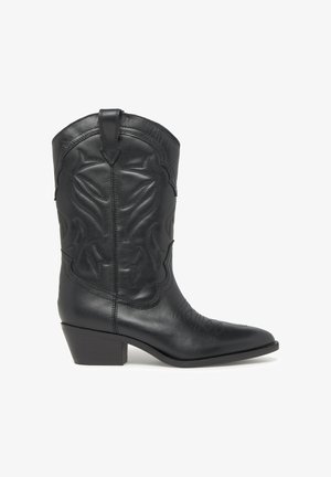 Bota vaquera de cuero negro con punta afilada, tacón bloque de altura media y costuras decorativas a lo largo del caña y la puntera.