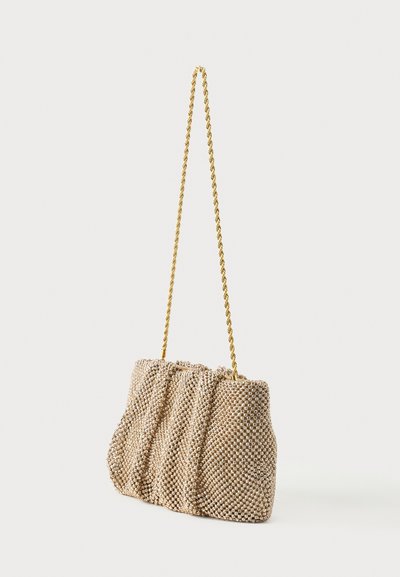 Μπεζ υφασμάτινη τσάντα χειρός με υφή διχτυού και ρυτιδιασμένες λεπτομέρειες, με μακρύ στριφτό χρυσό αλυσίδα.