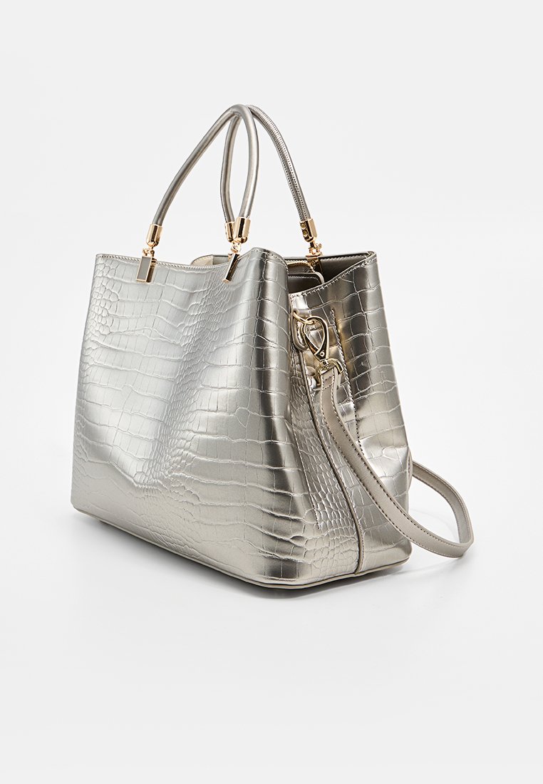 Sac à main en métal argenté avec une texture de crocodile, deux poignées supérieures, une bandoulière ajustable et des accents en métal doré.