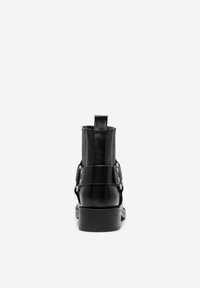 Bottine en cuir noir avec une finition lisse, dotée d'une languette arrière, de panneaux élastiques sur les côtés et d'une large sangle avec des rivets en métal.