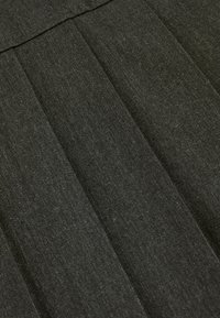 Dunkelgrauer Stoff mit strukturierter Oberfläche, der vertikale Falten und eine glatte Textur aufweist, geeignet für strukturierte Bekleidung.