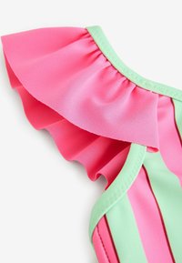 Traje de baño con ribete de volantes rosa y detalles en verde claro, con rayas verticales en colores vibrantes, fabricado con tela lisa y elástica.