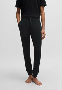 Svarta joggers i mjukt material, med ett elastiskt midjeband och dragsnodd samt ribbade muddar. Lämpliga för avslappnad användning.