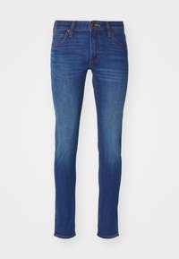 Slim fit dżinsy w ciemnoniebieskim denimu, z pięcioma kieszeniami, standardowym pasem z zapięciem na guzik oraz delikatnym przetarciem na udach.