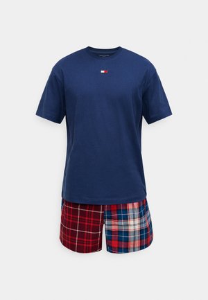 T-shirt en coton bleu marine à manches courtes avec un petit logo ; short à carreaux rouges et bleus avec des motifs et textures variés, doté d'une taille élastique.
