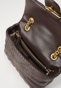 Geweven bruine handtas met een lederen interieur, gouden accenten en een ritsvak, met een gestructureerde vorm en een textuur aan de buitenkant.