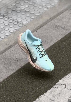Nike running shoe with a light blue mesh upper, black accents, and pink detailing. Features a cushioned beige sole and black laces.