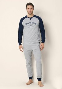Top grigio a maniche lunghe con maniche raglan blu navy, con grafica "Sports Club", abbinato a joggers grigi con polsini blu navy.