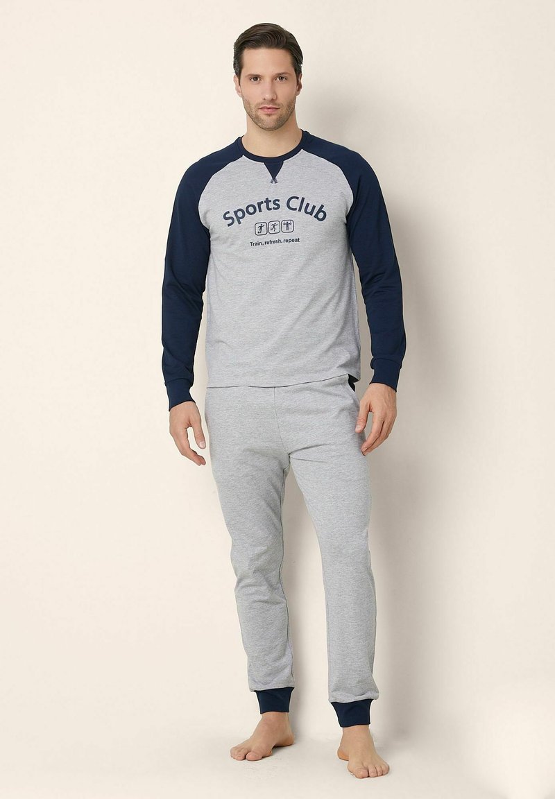 Top grigio a maniche lunghe con maniche raglan blu navy, con grafica "Sports Club", abbinato a joggers grigi con polsini blu navy.
