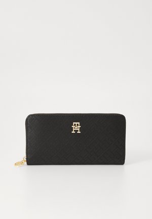 Portefeuille zippé noir en matériau texturé avec un accent logo doré sur le devant et un motif géométrique.